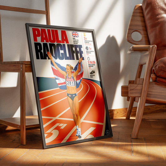 A framed poster of Paula Radcliffe leaning against a wall on a wooden floor, flanked by wooden chairs in a sunlit room.