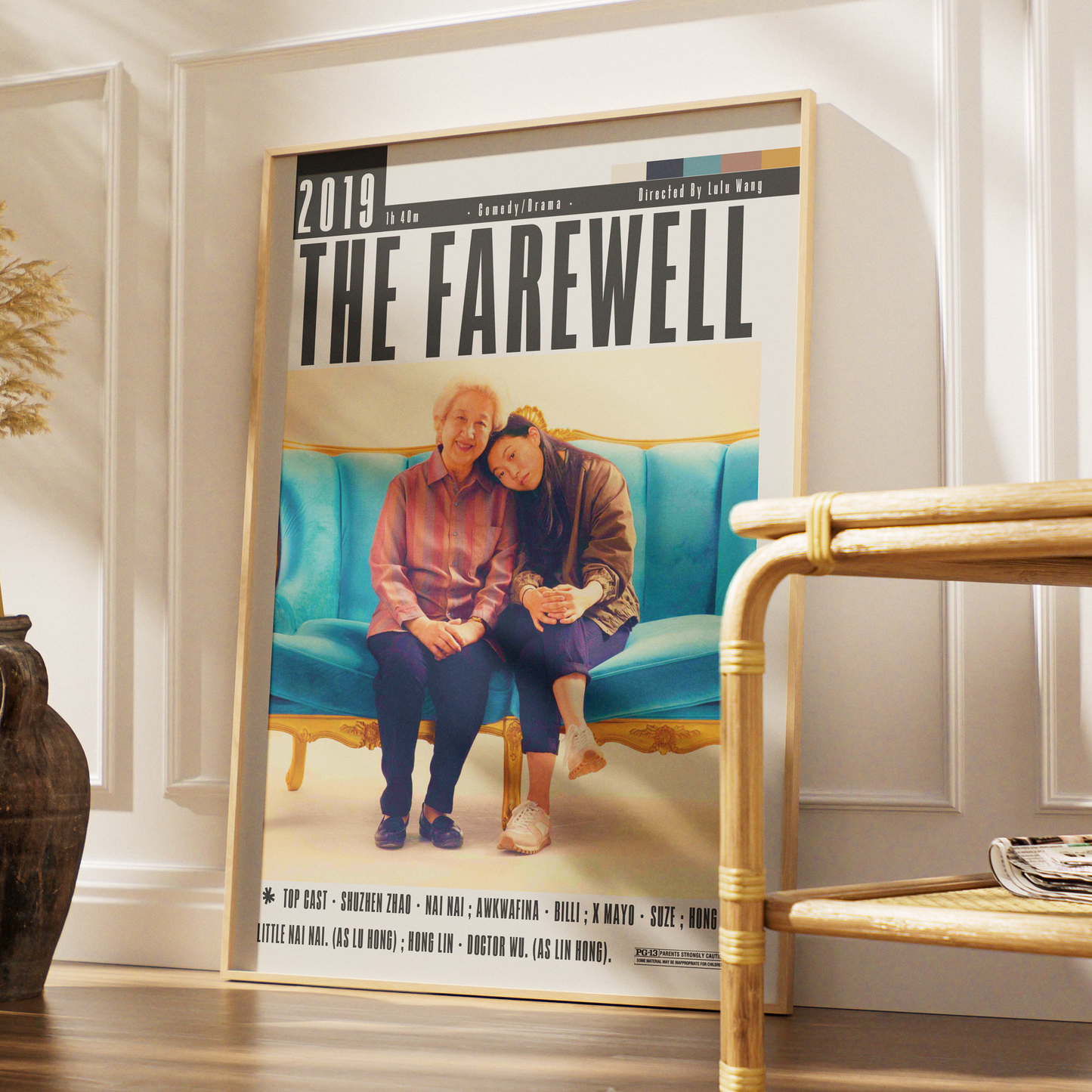A framed poster titled "THE FAREWELL 2019" leaning against a white wall in a styled interior. The poster features a photo of an elderly couple sitting on a turquoise sofa, with large black title text at the top.