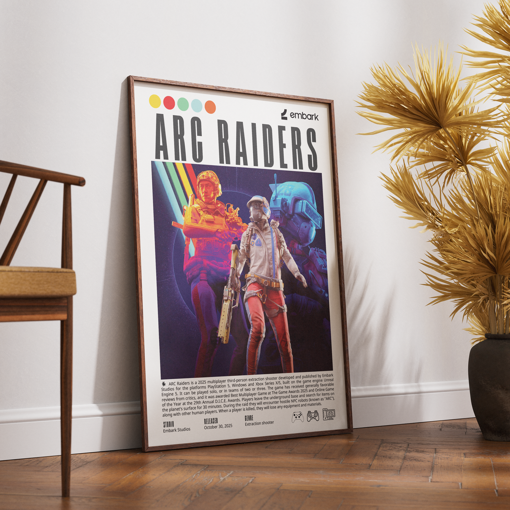 A framed poster titled 'ARC RAIDERS' leaning against a white wall on a wooden floor, with a wooden chair on the left and a potted palm on the right. The poster features colorful sci-fi character artwork and text, including the 'embark' logo.