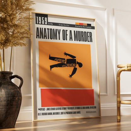 A framed vintage-style movie poster for the 1959 film 'Anatomy of a Murder' leaning against a white wall on a wooden floor, with a dark vase and part of a chair in the room.