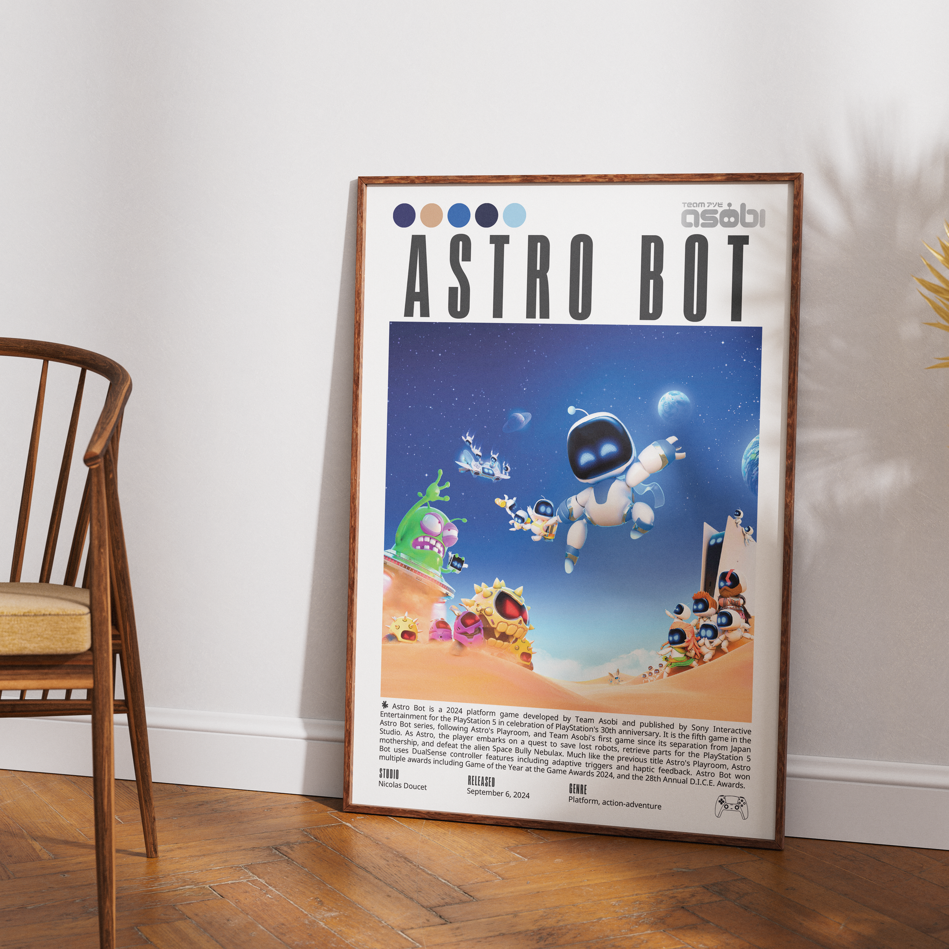 A framed retro-style 'Astro Bot' poster leaning against a white wall on a wood floor, with part of a wooden chair visible on the left. The poster features colorful sci-fi artwork and text, including the Asobi brand mark.