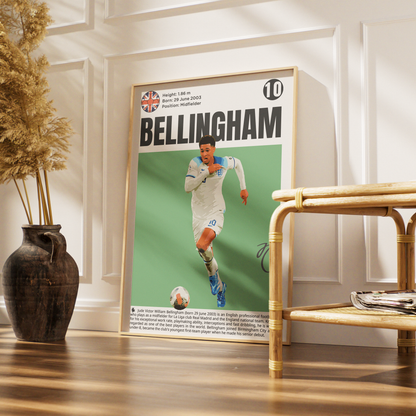 A framed vertical soccer poster featuring Bellingham, styled in a modern living room setting next to a bamboo side table and a dark ceramic vase with dried grass.