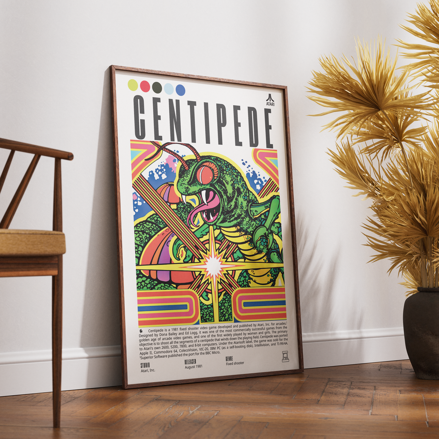 A framed Centipede music poster leaning against a white wall on a wooden floor, next to a wooden chair and a potted palm plant.