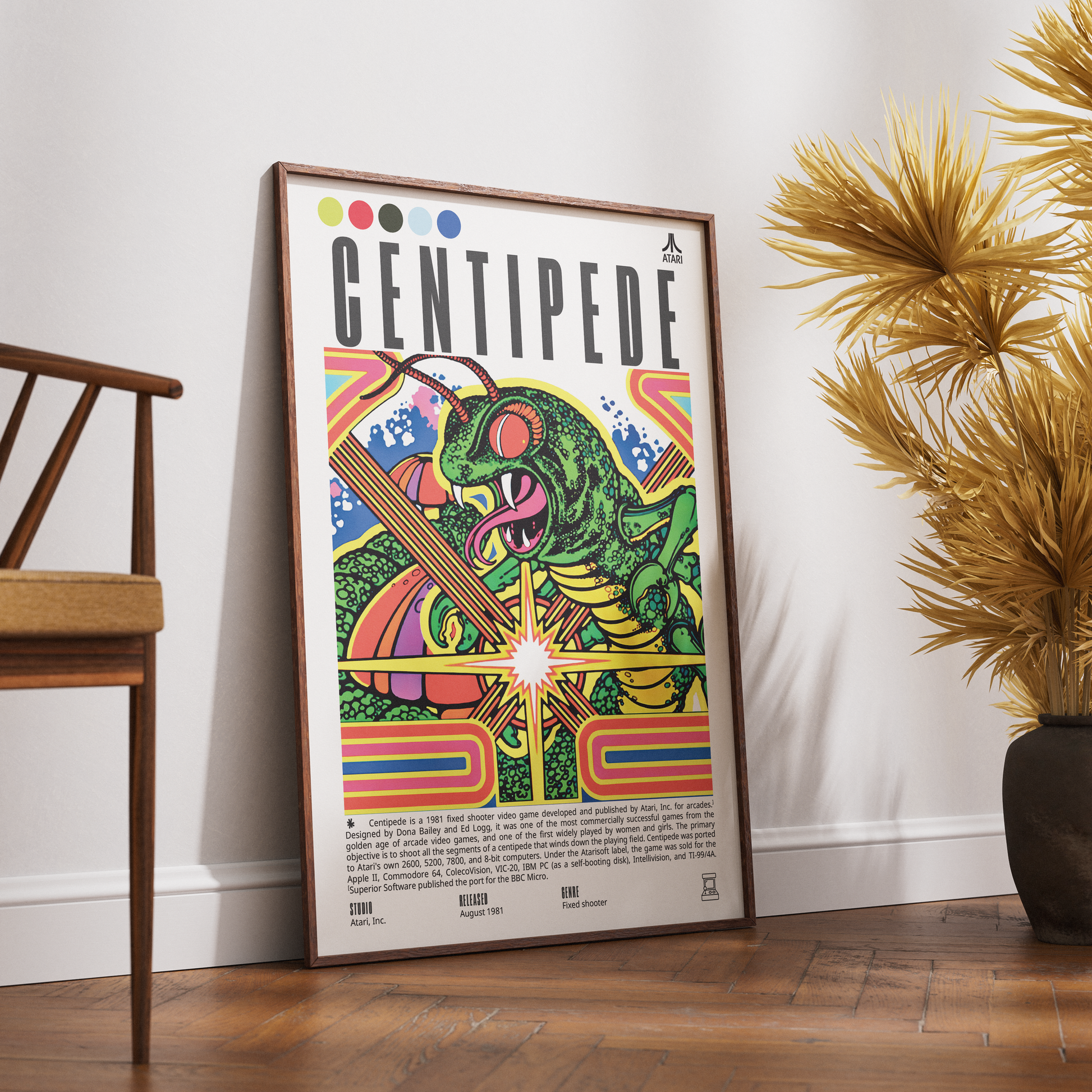 A framed Centipede music poster leaning against a white wall on a wooden floor, next to a wooden chair and a potted palm plant.