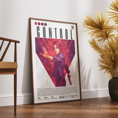 A framed poster of the video game Control leaning against a white wall on a wooden floor, styled with a wooden chair on the left and a potted plant on the right.