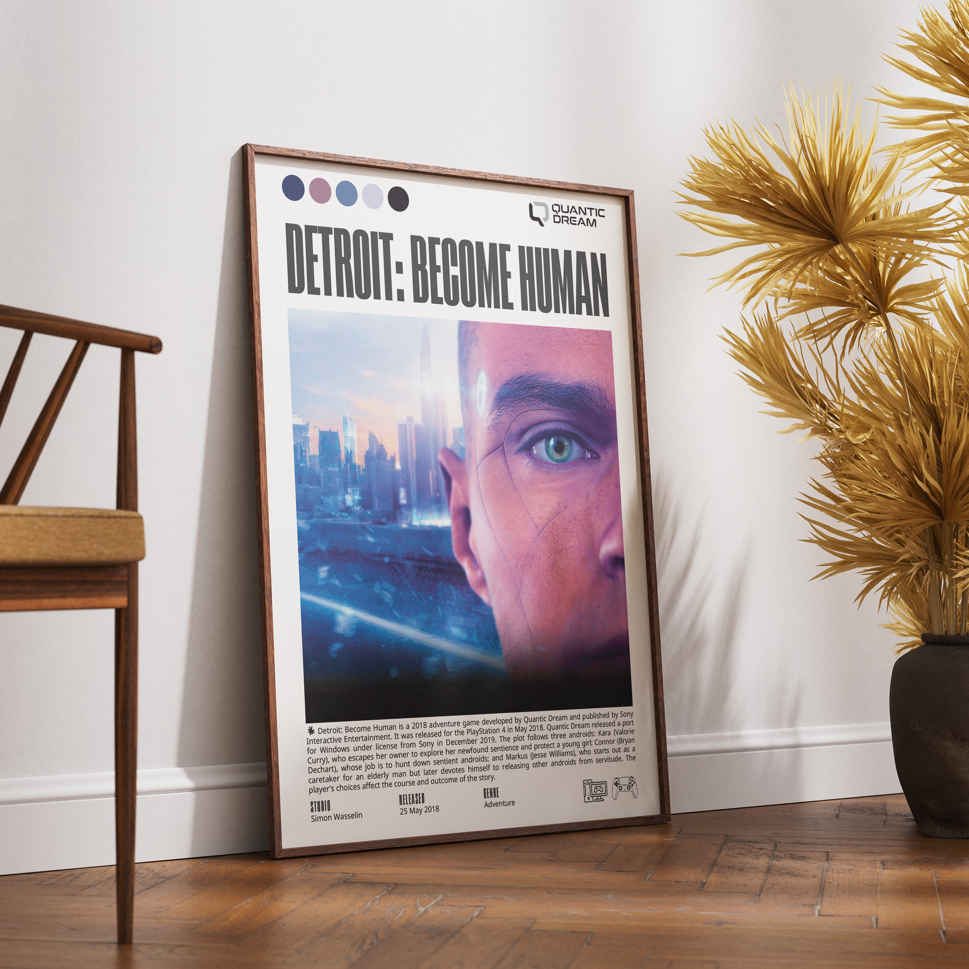 A framed vertical poster titled 'DETROIT: BECOME HUMAN' leaning against a white wall on a wood floor, with a wooden chair on the left and a potted palm on the right.