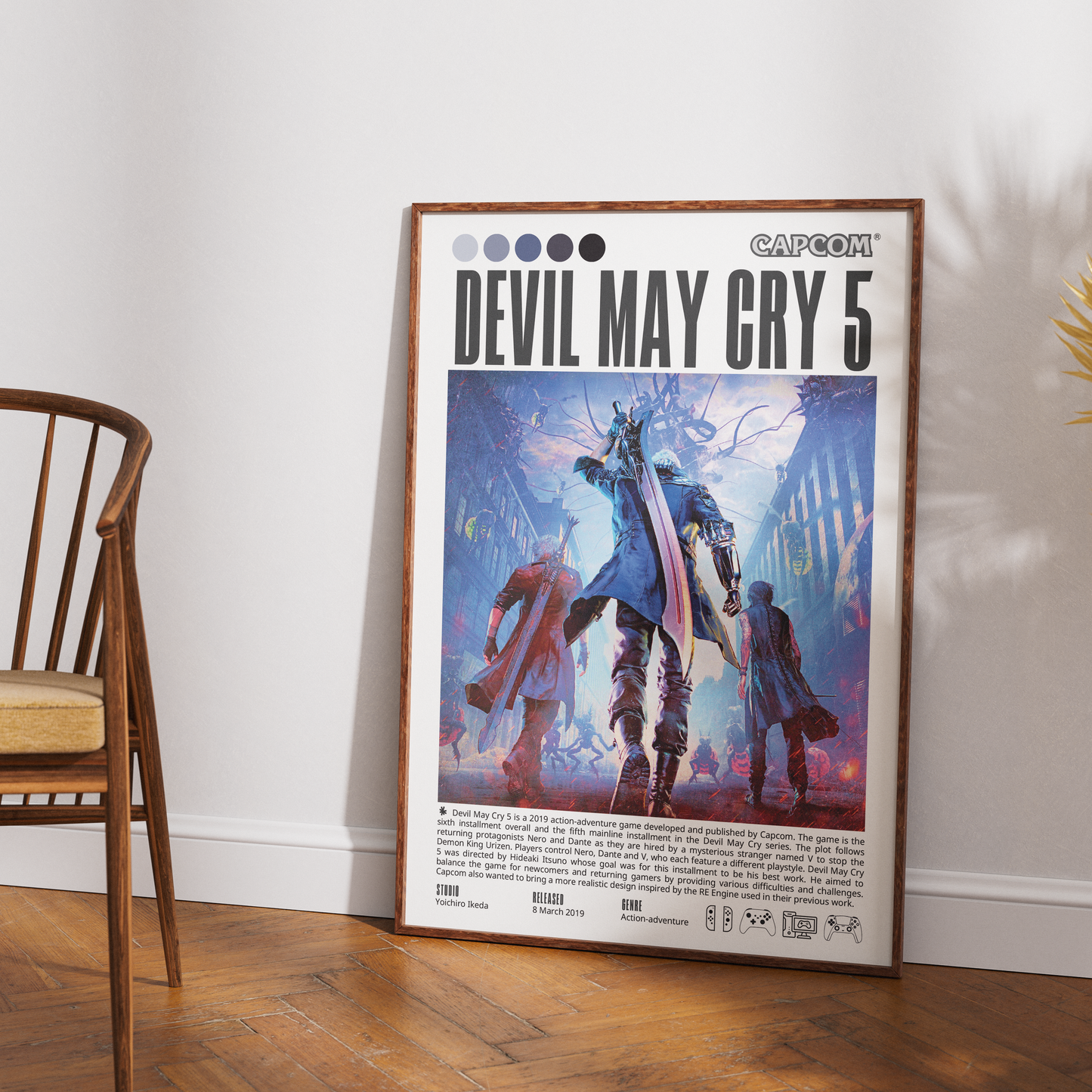A framed Capcom Devil May Cry 5 poster leaning against a white wall on a wooden floor, with part of a wooden chair visible on the left.