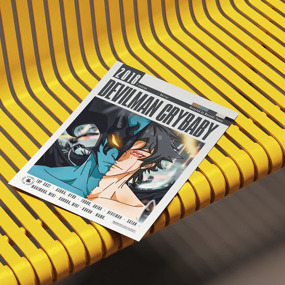 A printed magazine or album cover titled "2016 Devilman Crybaby" lies on a bright yellow ribbed bench. The cover features anime-style artwork with a dark-haired character in a teal top and black jacket, with track listing text along the bottom.
