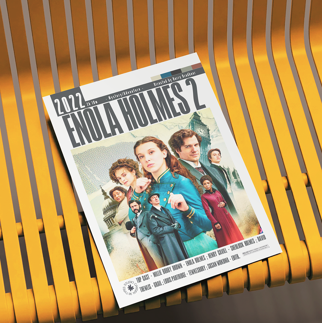 A printed magazine or book cover titled "Enola Holmes 2" lies on a yellow slatted bench. The cover features a group portrait of characters in period clothing, with the title and cast names visible.