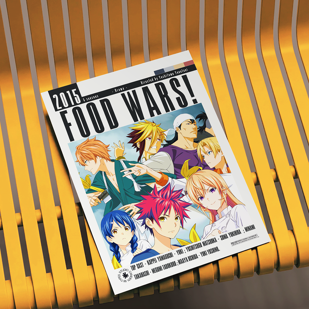 A printed magazine or book cover titled "Food Wars!" 2015 Edition lies on a yellow slatted chair. The cover features colorful anime characters and text including "Food Wars!" and "2015 Edition.