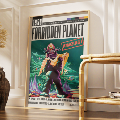 A framed vintage-style poster for the 1956 film 'Forbidden Planet' leaning against a white paneled wall in a styled interior setting with a bamboo side table and wooden floor.