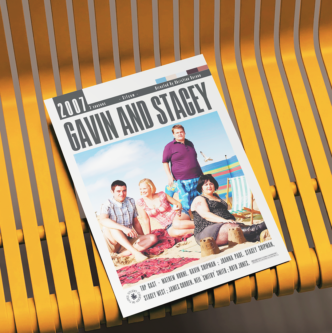 A printed movie poster for the 2007 film 'Gavin and Stacey' is displayed at an angle on a yellow slatted bench. The poster features the cast members sitting and standing on a beach, with the title 'GAVIN AND STAGEY' in large black letters at the top.