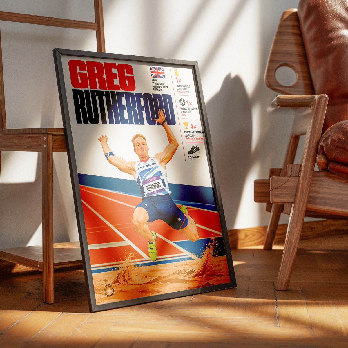A framed sports poster of Greg Rutterford, a track and field athlete, leaning against a wall in a modern room with wooden furniture and warm sunlight.