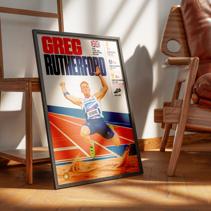 A framed sports poster of Greg Rutterford, a track and field athlete, leaning against a wall in a modern room with wooden furniture and warm sunlight.