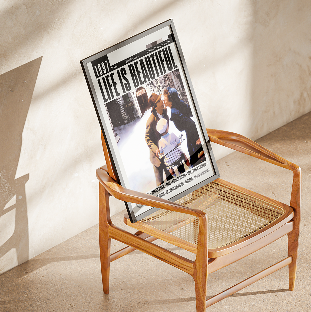 A framed vintage magazine or poster leaning against a wooden armchair in a sunlit room. The print features the text '1993 LIFE IS BEAUTIFUL' and a black-and-white photograph with smaller text along the bottom.