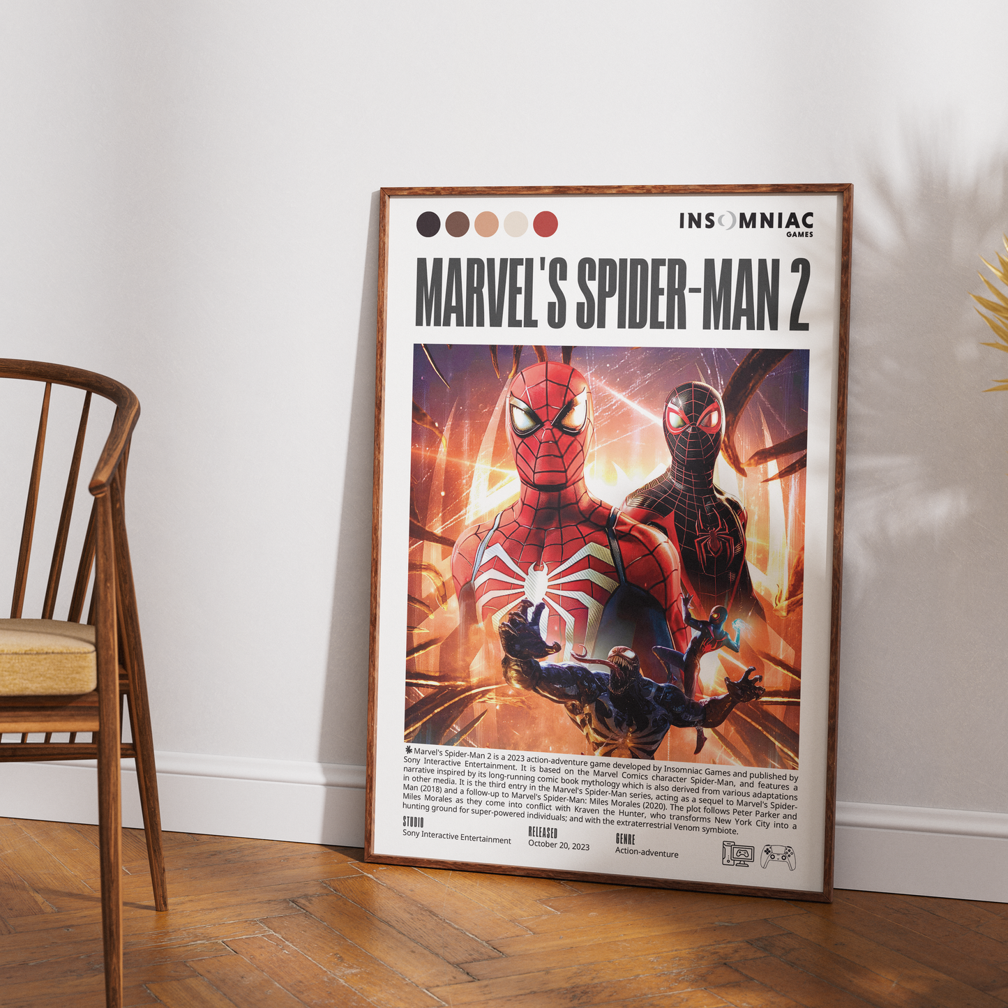 A framed Marvel's Spider-Man 2 movie poster leaning against a white wall on a wooden floor, with part of a wooden chair visible on the left.
