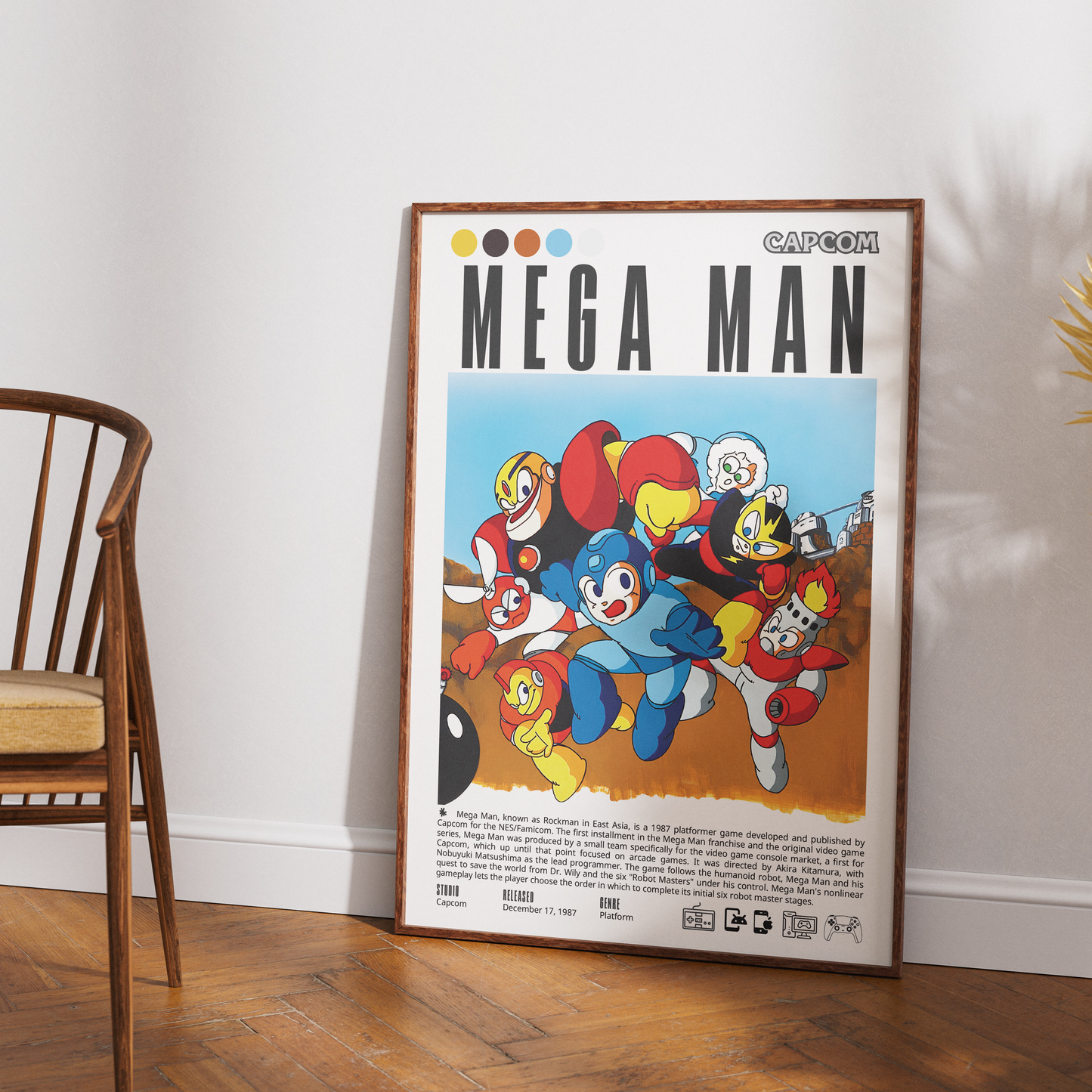 A framed vintage-style Capcom Mega Man poster leaning against a white wall on a wood floor, with part of a wooden chair visible on the left.