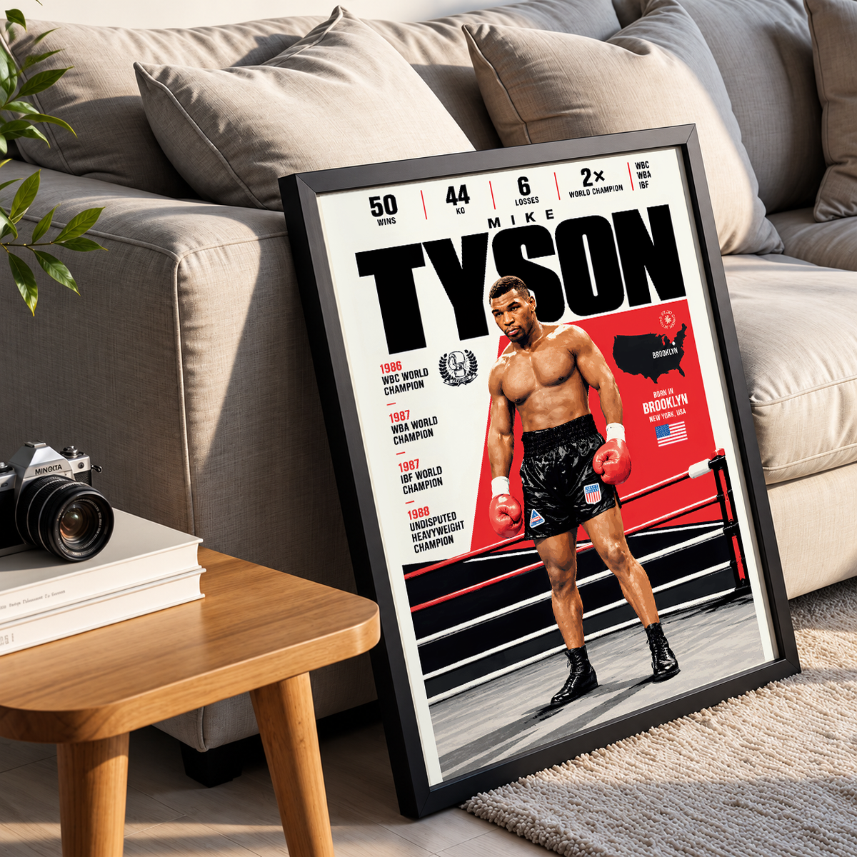 A framed poster of Mike Tyson styled in a modern living room setting, leaning against a beige sofa next to a wooden side table with a camera.