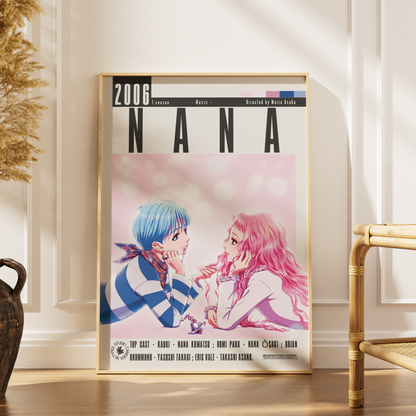 A framed anime poster of Nana from 'Nana 2006' leaning against a white paneled wall on a wooden floor, with a dried plant and a bamboo chair partially visible in the room.