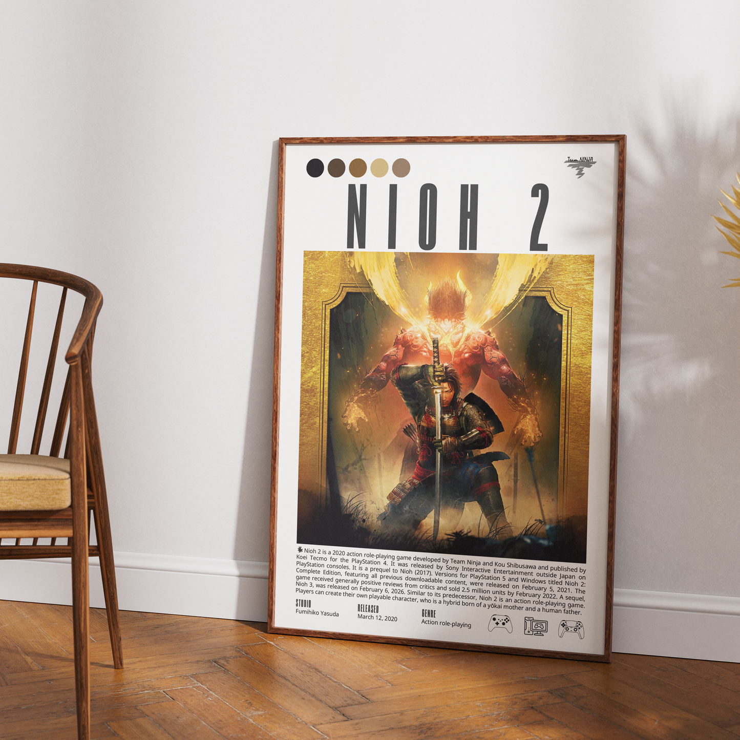 A framed NIOH 2 art poster leaning against a white wall on a wooden floor, with a wooden chair partially visible on the left.