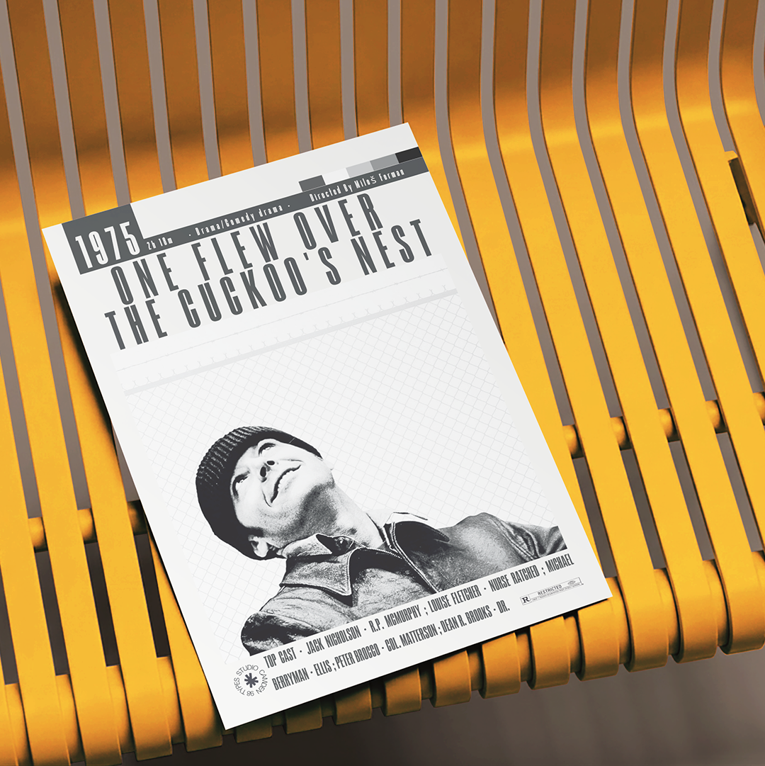A printed book or magazine cover titled "One Flew Over the Cockrooper's Nest" lies diagonally on a yellow slatted chair. The cover is mostly white with black text and a black-and-white portrait photo near the bottom.