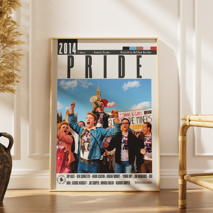 A framed poster of the 2014 London Pride festival, leaning against a white paneled wall on a wooden floor next to a rattan chair.