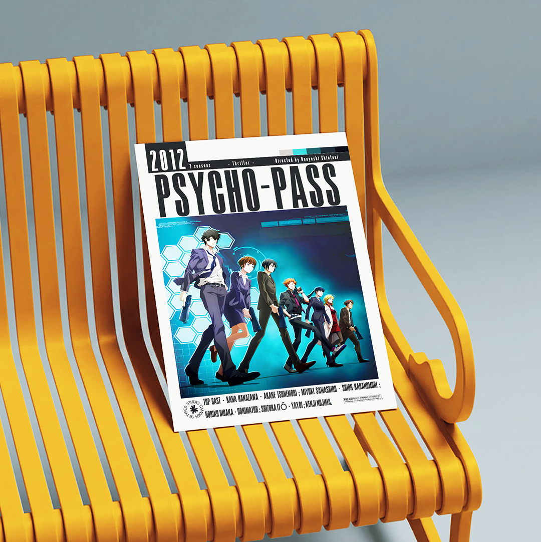 A magazine or book titled 'PSYCHO-PASS 2017' with anime cover art, leaning against a bright yellow slatted bench on a gray studio background.