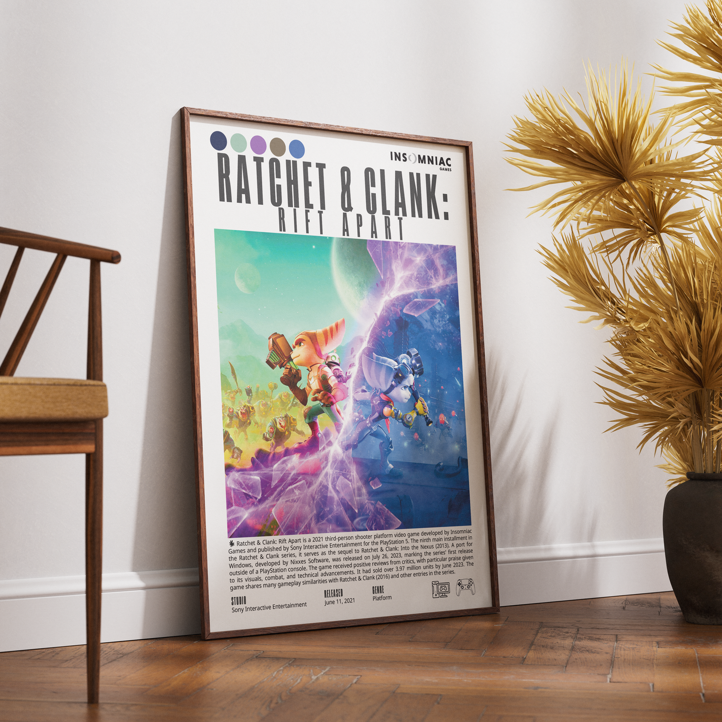 A framed art print of 'Ratchet & Clank: Rift Apart' leaning against a white wall on a wooden floor, styled with a wooden chair on the left and a potted palm on the right.