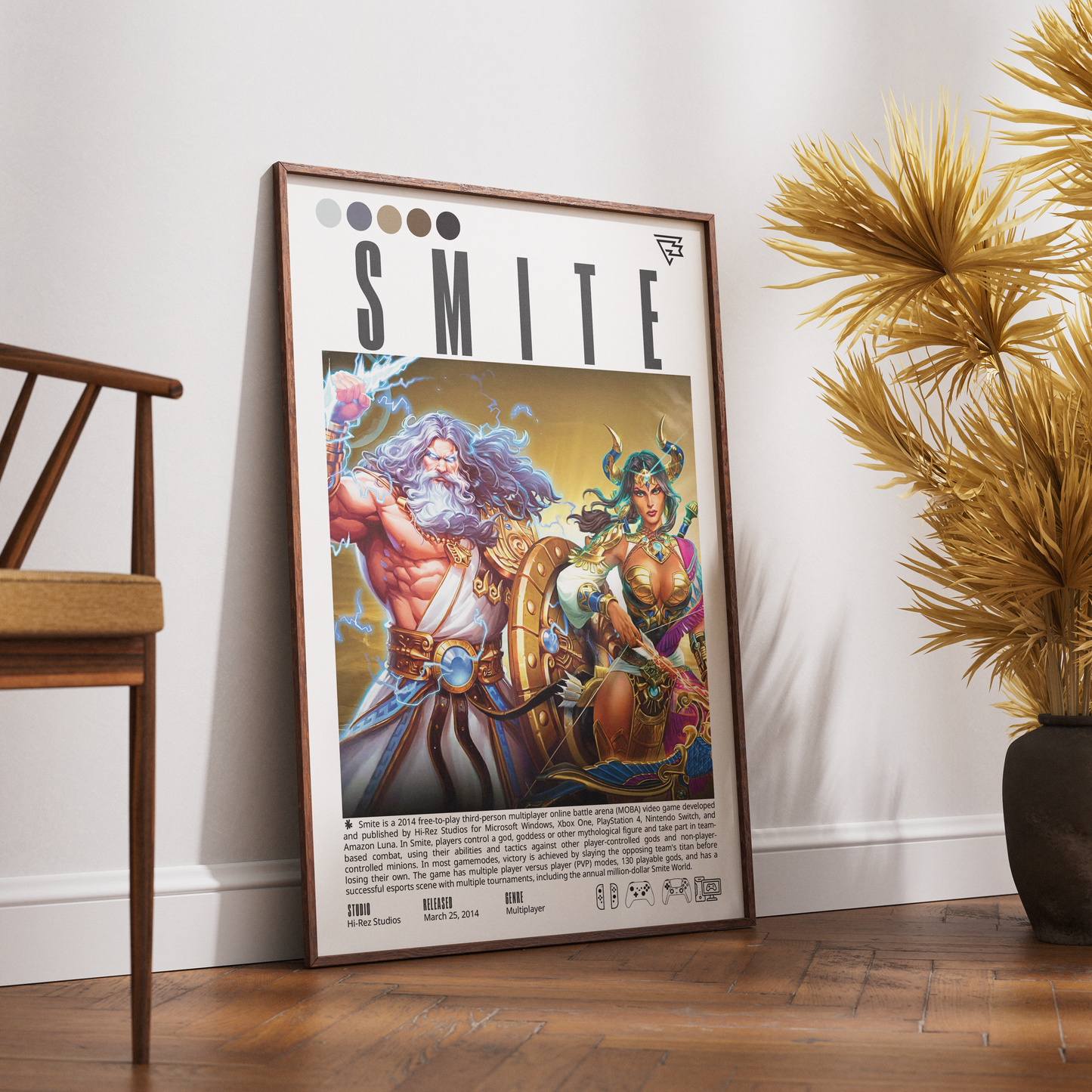A framed art print featuring the 'SMITE' video game cover art, styled leaning against a white wall on a wooden floor next to a wooden chair and a potted plant.