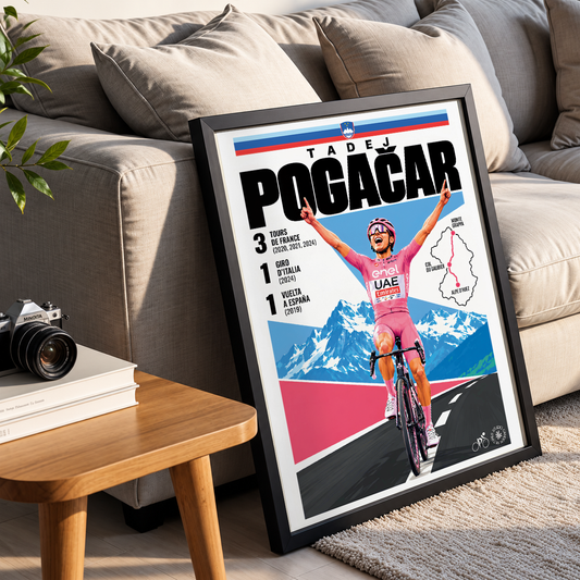 A framed poster leaning against a beige sofa in a living room setting. The poster features a stylized illustration of cyclist Tadej Pogacar celebrating, with the text 'TADEJ POGAČAR' and mountain scenery in blue, pink, white, and black.