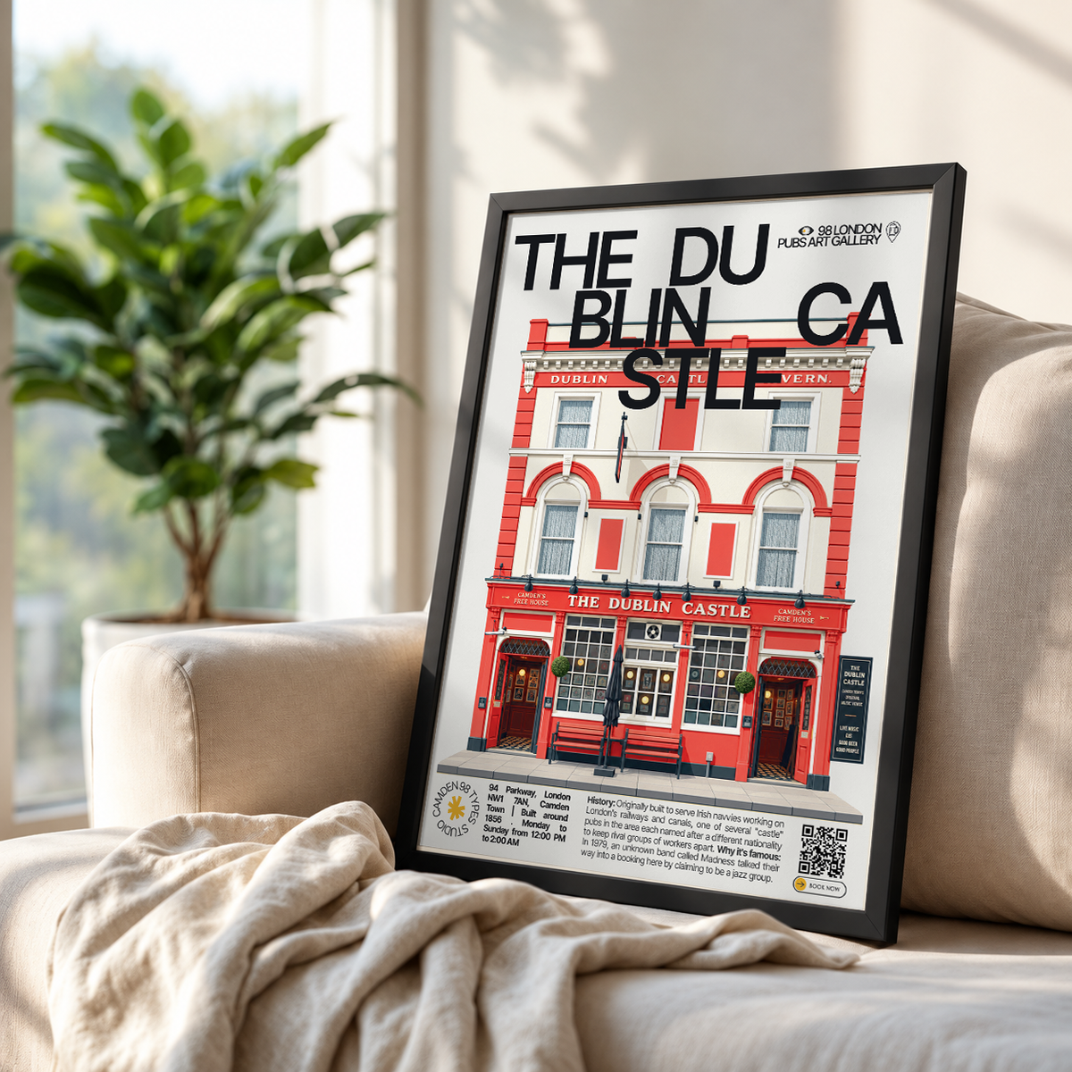 A framed art print leaning against a beige sofa in a living room setting. The print features a stylized illustration of 'The Dublin Castle' pub with the text 'THE DU BLIN CA STLE' across the top.