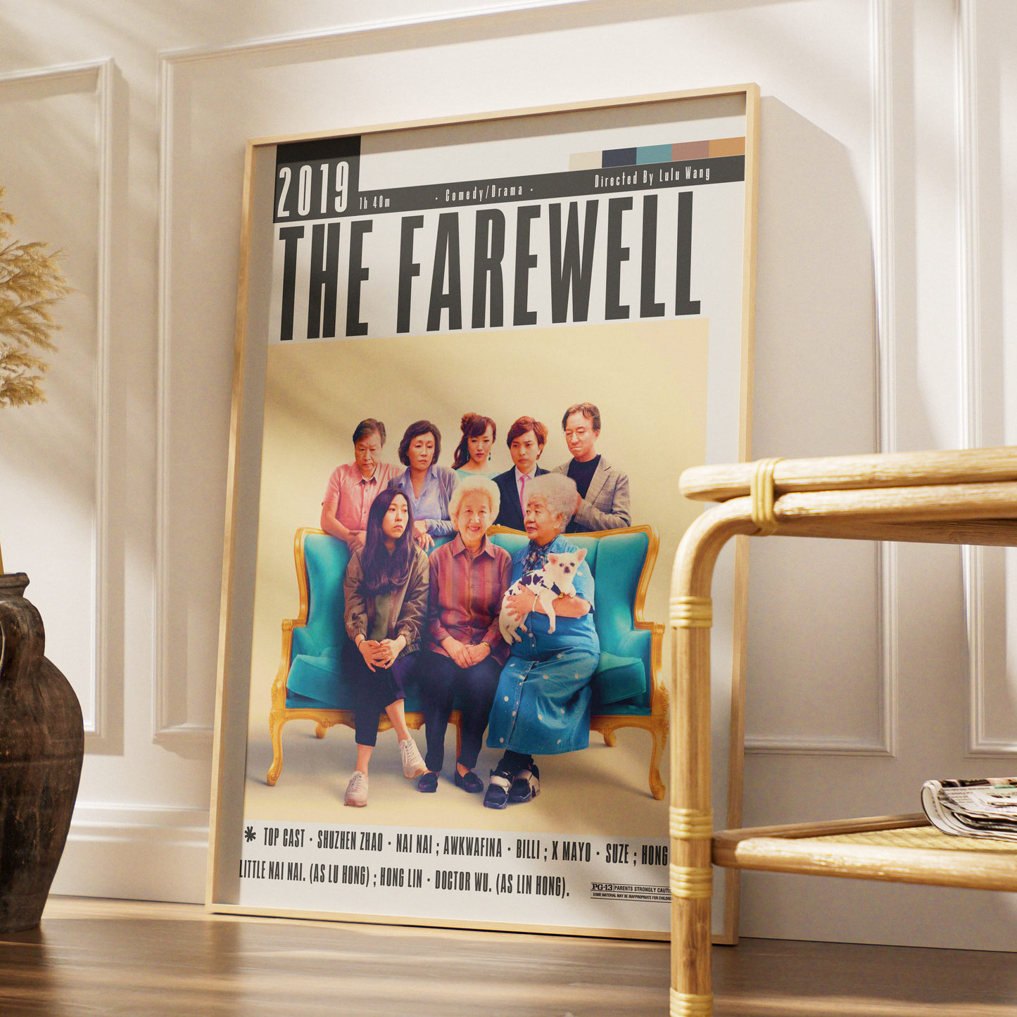 A framed poster of the TV show 'The Farewell' leaning against a white paneled wall in a styled interior setting with a wooden shelf and vase.