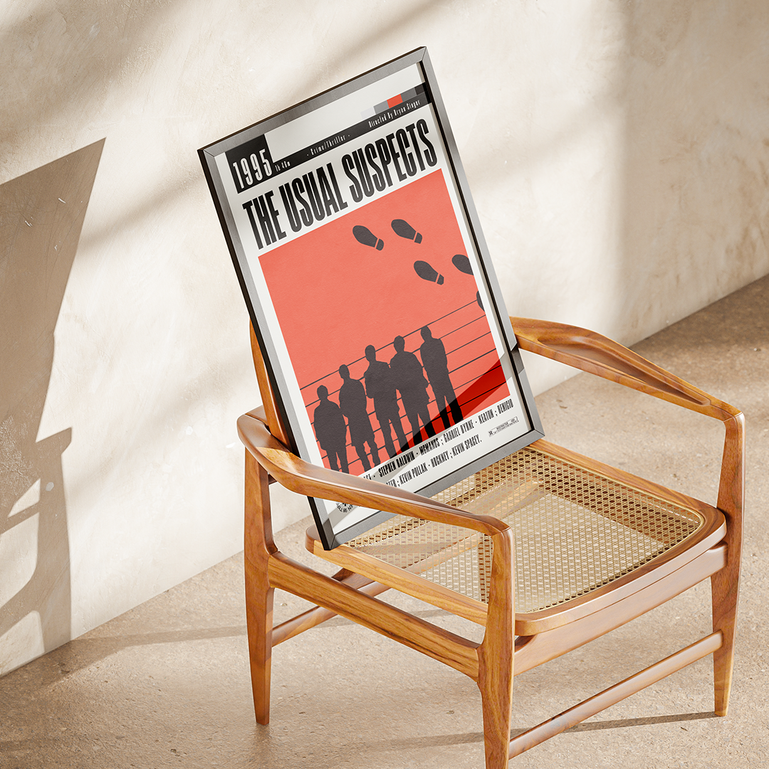 A framed poster of the movie 'The Usual Suspects' leaning against a wooden cane-back armchair in a sunlit room.