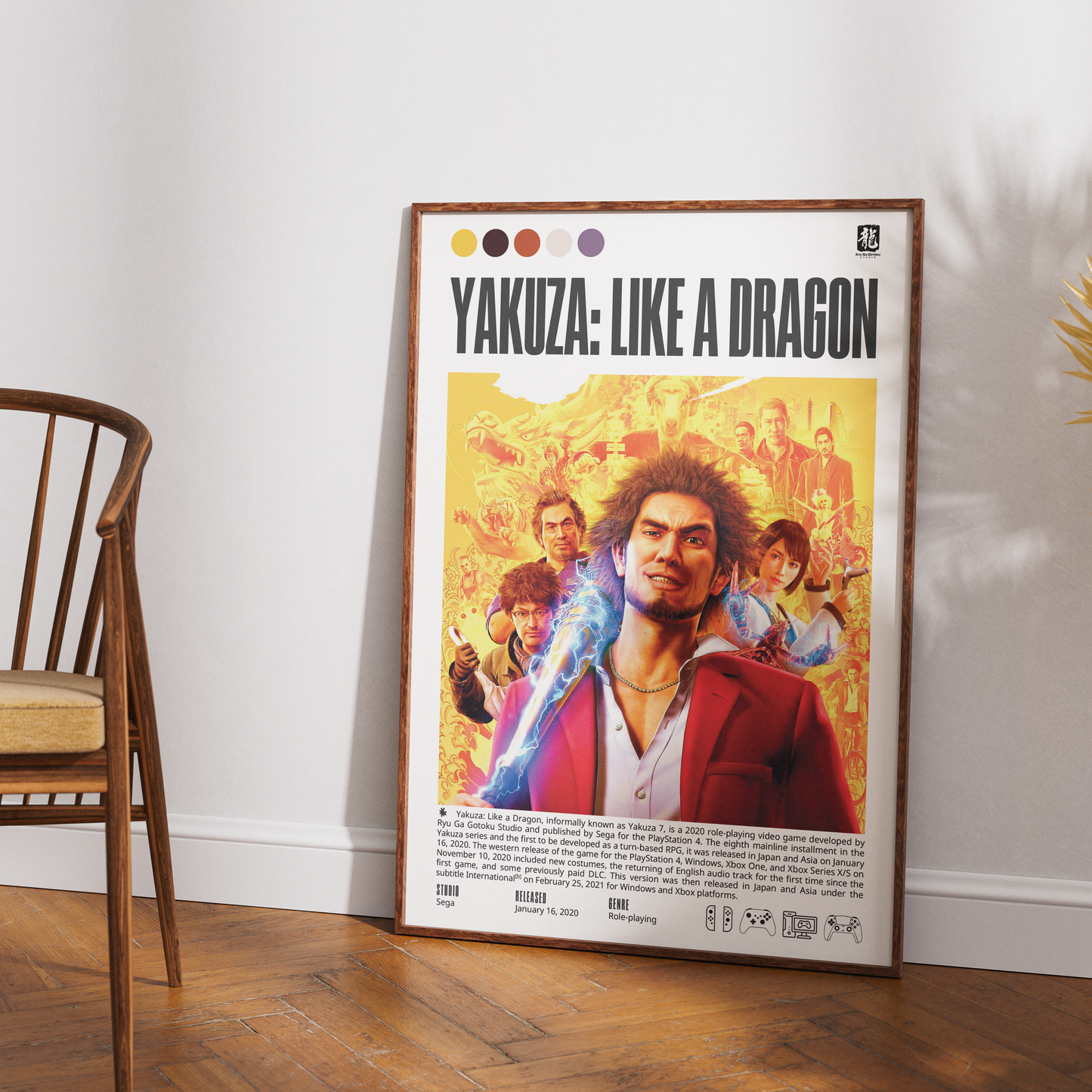 A framed poster of the movie 'Yakuza: Like a Dragon' leaning against a white wall on a wooden floor, next to a wooden chair.