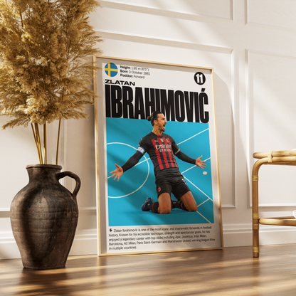 A framed vertical poster featuring Zlatan Ibrahimovic with a blue background and his AC Milan jersey, styled on a wooden floor next to a dark ceramic vase with dried grass and a gold side table.