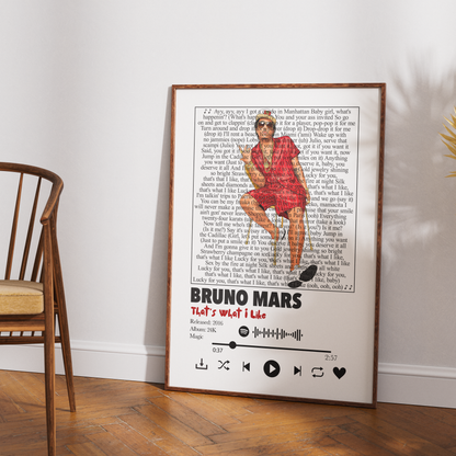 A framed music-themed poster of Bruno Mars leaning against a white wall on a wooden floor, next to a wooden chair.