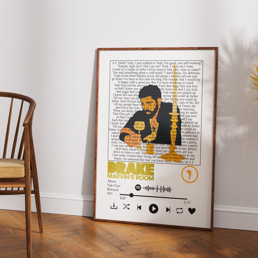 A framed art print featuring a stylized portrait of Drake with song lyrics and the text 'Drake - Marvin's Room' in a music player design, leaning against a white wall on a wooden floor next to a chair.
