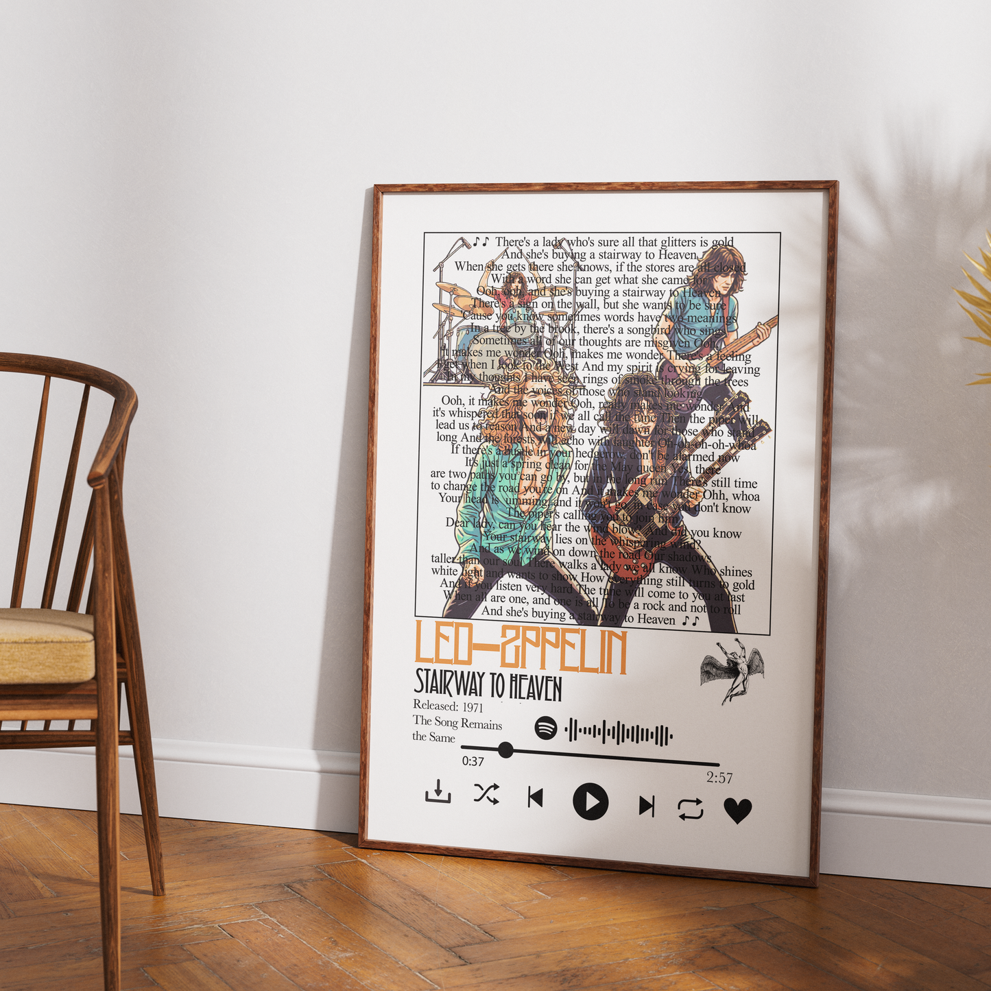 A framed music poster of the band Led Zeppelin, featuring album artwork and lyrics on a vintage book page background, leaning against a white wall on a wooden floor next to a wooden chair.