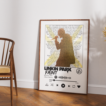 A framed Linkin Park 'Faint' album art print leaning against a white wall on a wooden floor, with a wooden chair partially visible on the left.