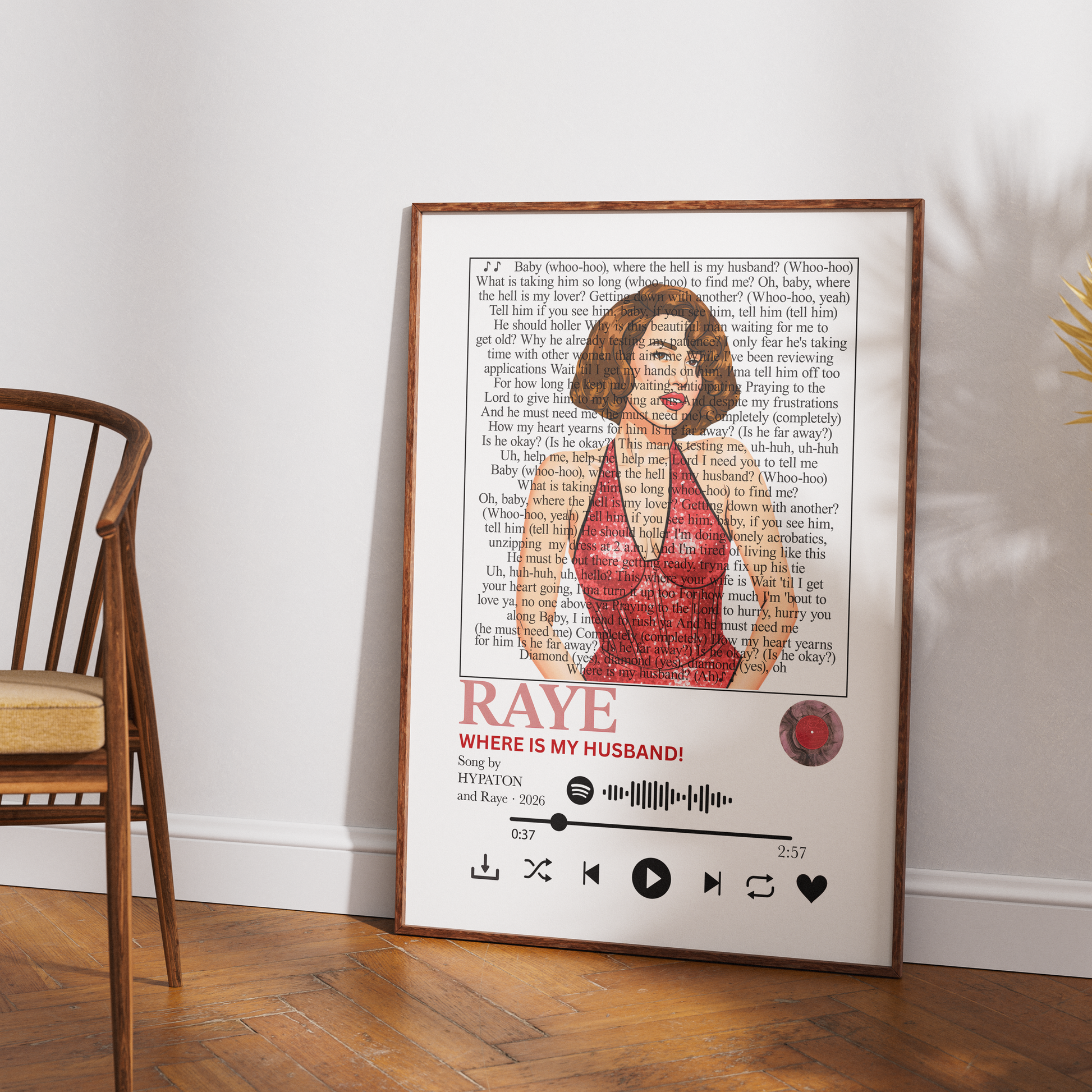 A framed personalized music poster featuring a red-haired woman in a red dress with the text 'RAYE' and 'WHERE IS MY HUSBAND!' above a playback bar, leaning against a white wall on a wooden floor next to a wooden chair.